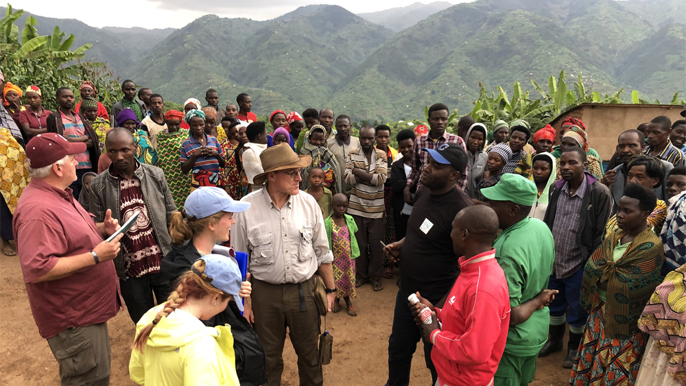 A large group of people gathered around discussing and listening to each other. 