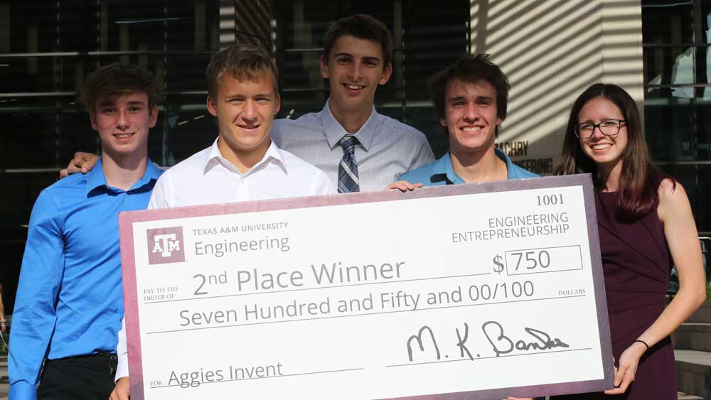 Group photo of 4 men and a woman with a giant check 