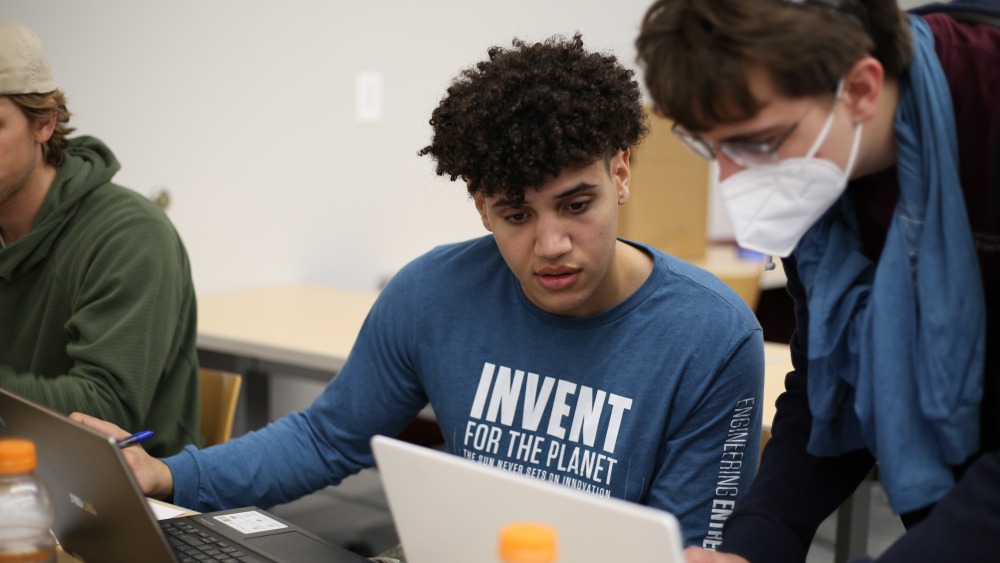 Students collaborate using a laptop during Invent for the Planet part one.