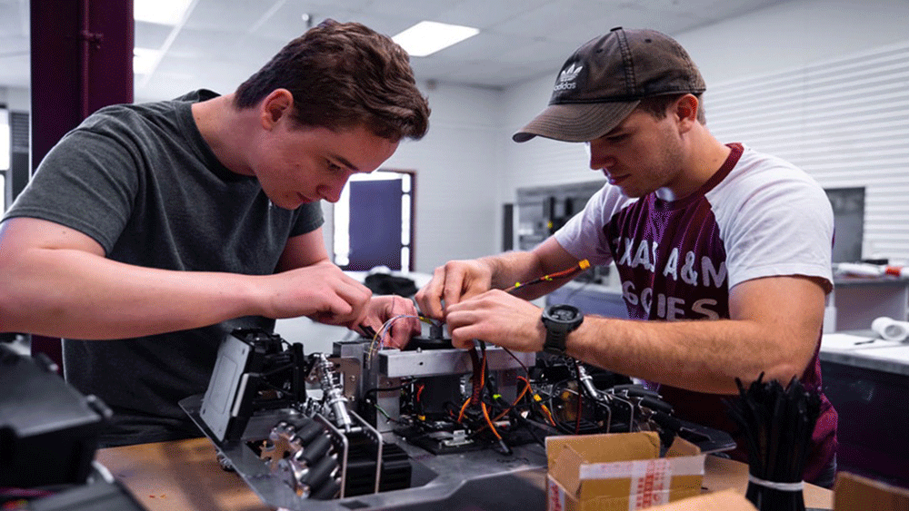 Two guys working on building a giant computer.