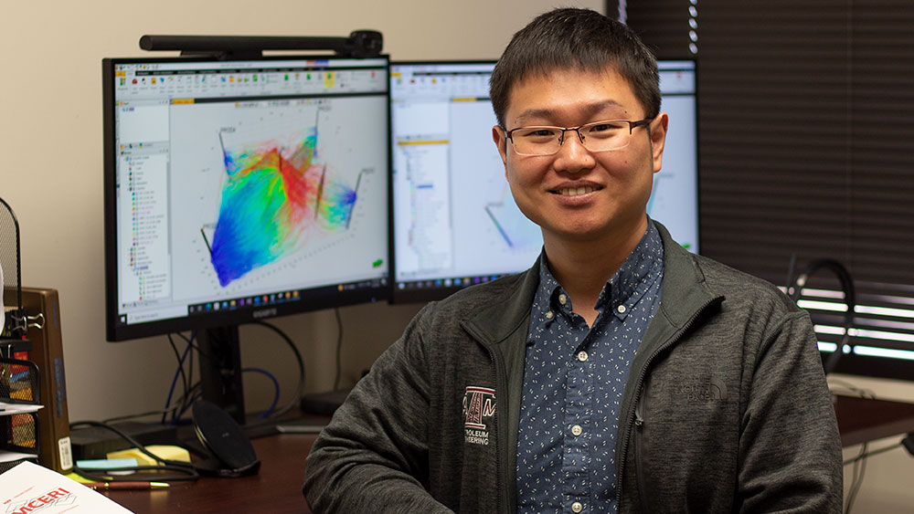 Dr. Hongquan Chen smiling while seated in front of a computer display