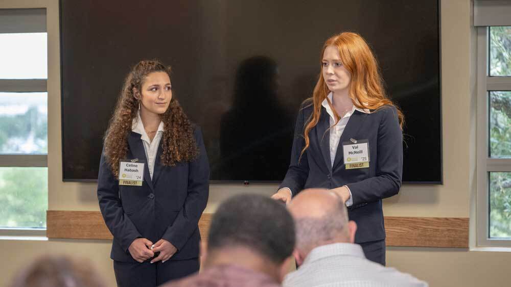 Val McNeil and her teammate present to a room of judges and guests.