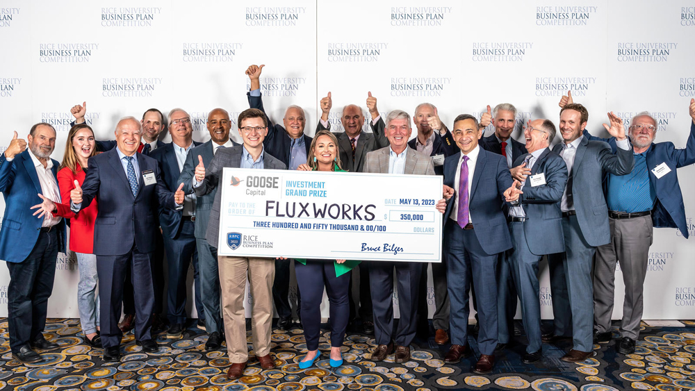 Members of FluxWorks holding a check for $350,000 with members of Goose Capital and the Rice Business Plan Competition.