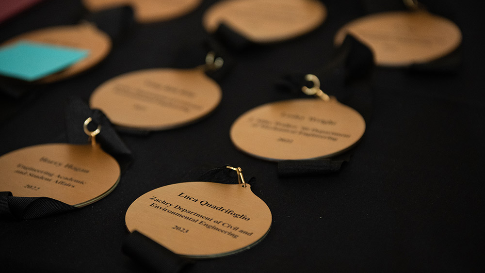 Bronze engraved medals sitting on a black background.