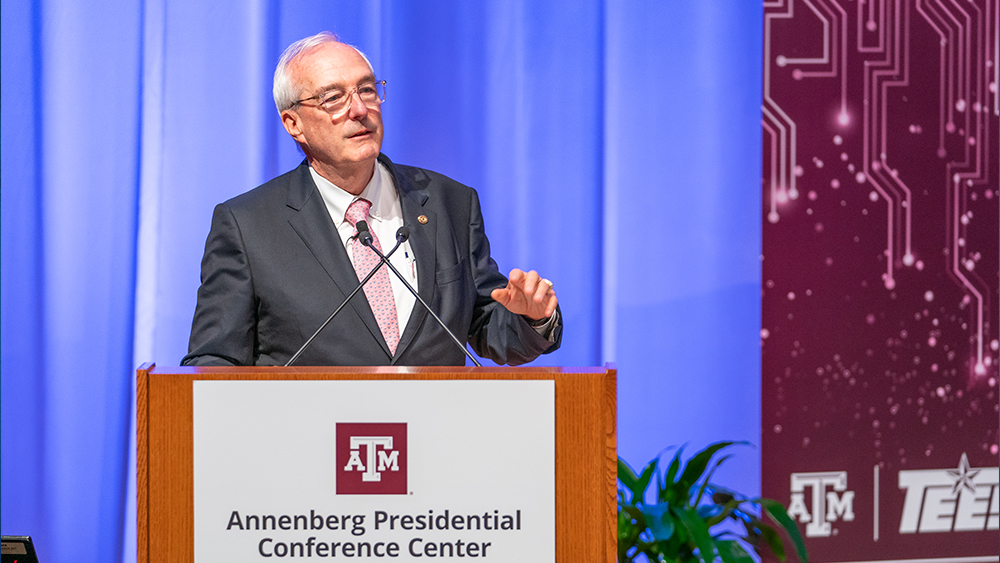 Ray Rothrock delivers opening remarks at a podium at the Global Cyber Research Institute Summit.