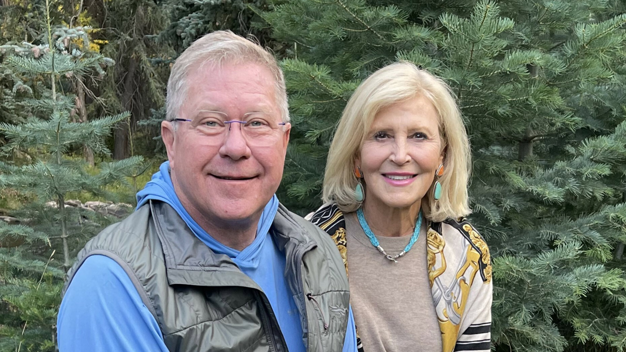 Susan and James F. "Jim" Thompson ’83 posing for a photo while sitting on a rock outdoors.