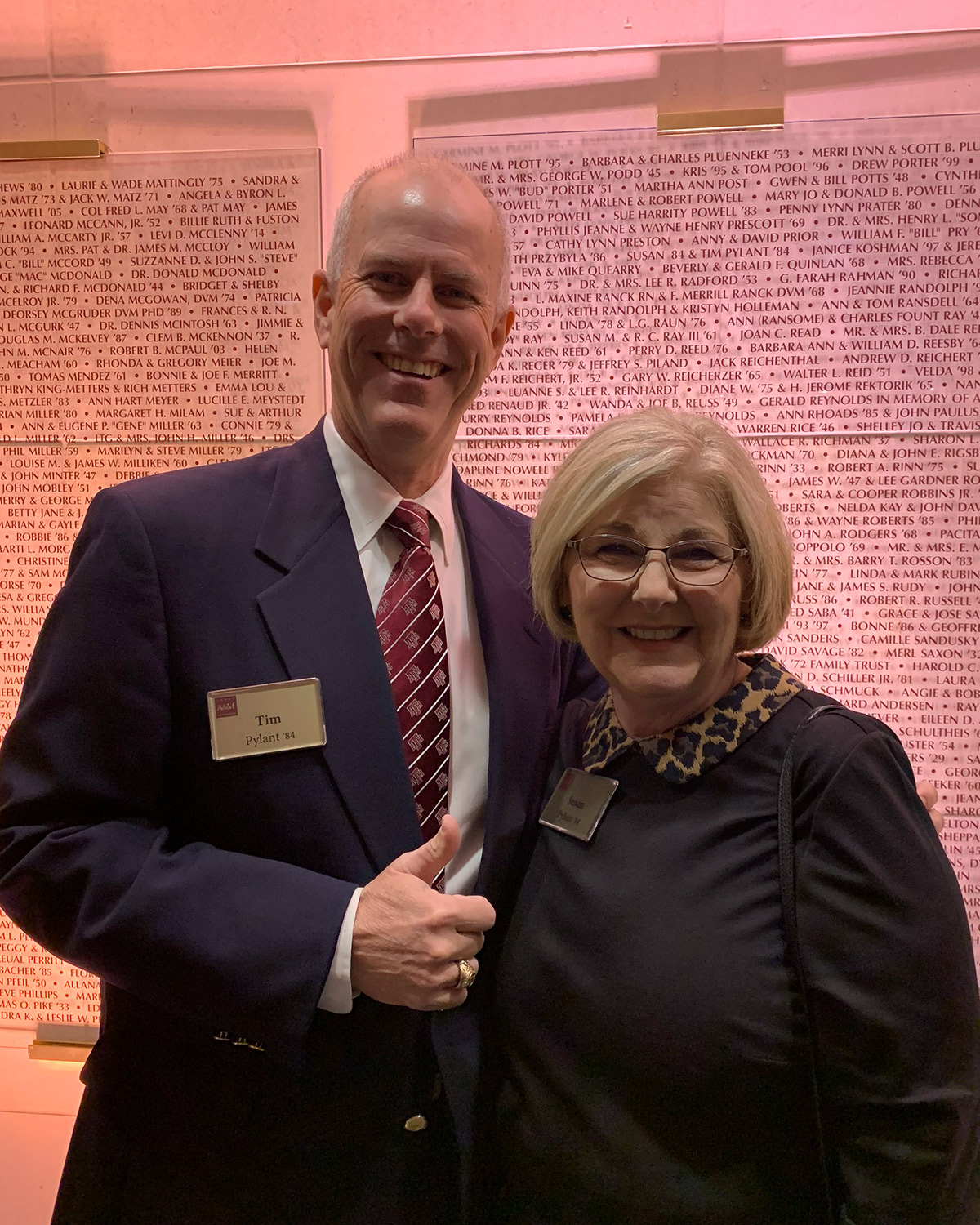 Timothy ’84 and Susan ’84 Pylant in front of the A&amp;M legacy wall in Aggie Park.