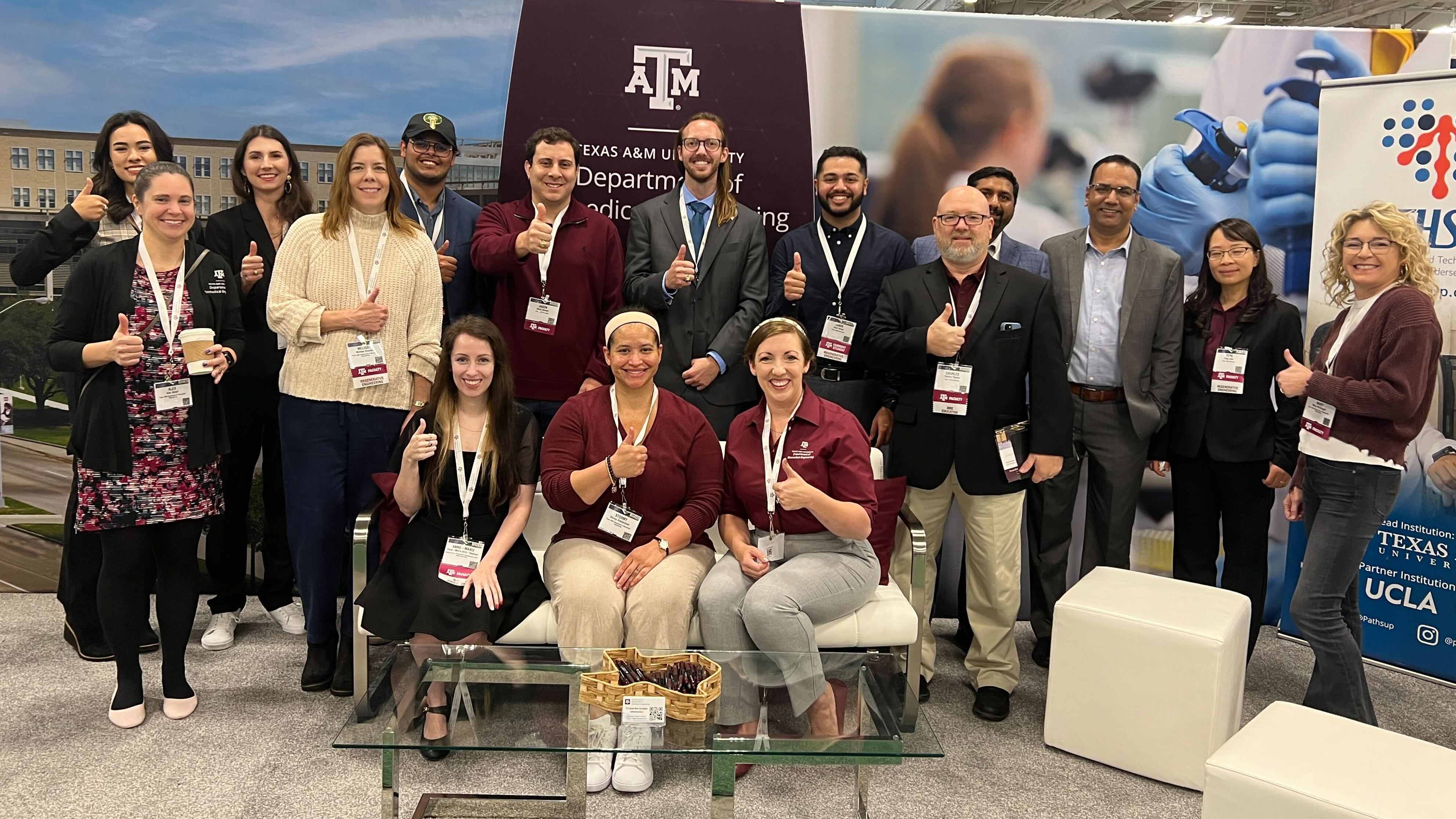 Staff, students and faculty posing in front of the Texas A&M Department of Biomedical Engineering booth at the Biomedical Engineering Society meeting.