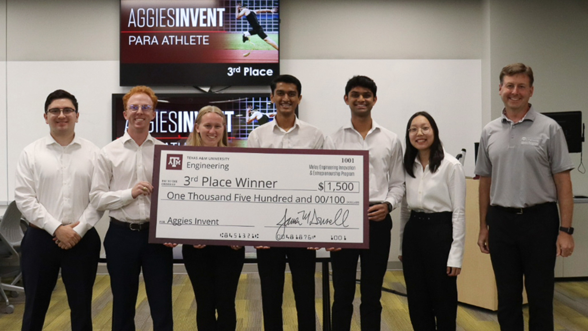 Students holding a large check for $1,500 that says “3rd Place Winner.”