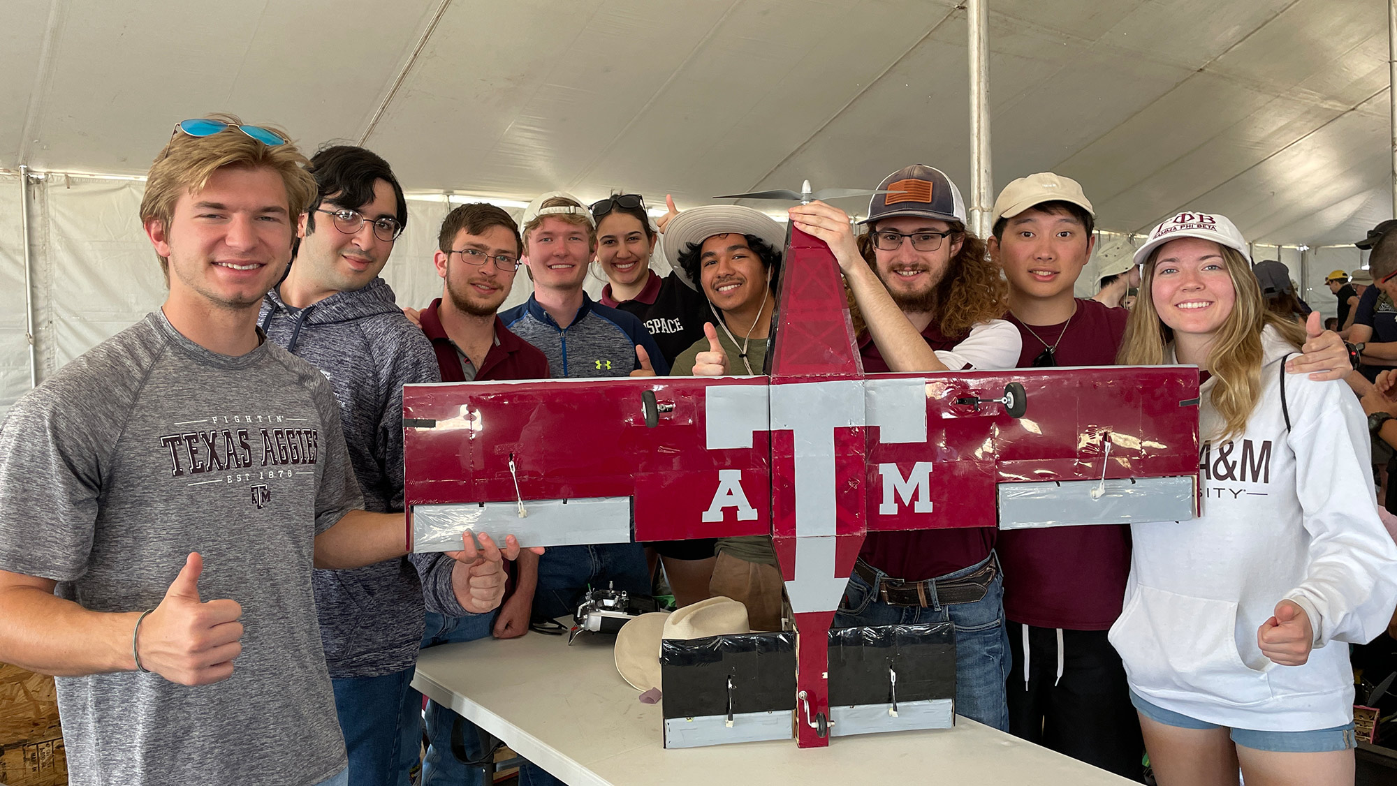 Group of students standing around a project.