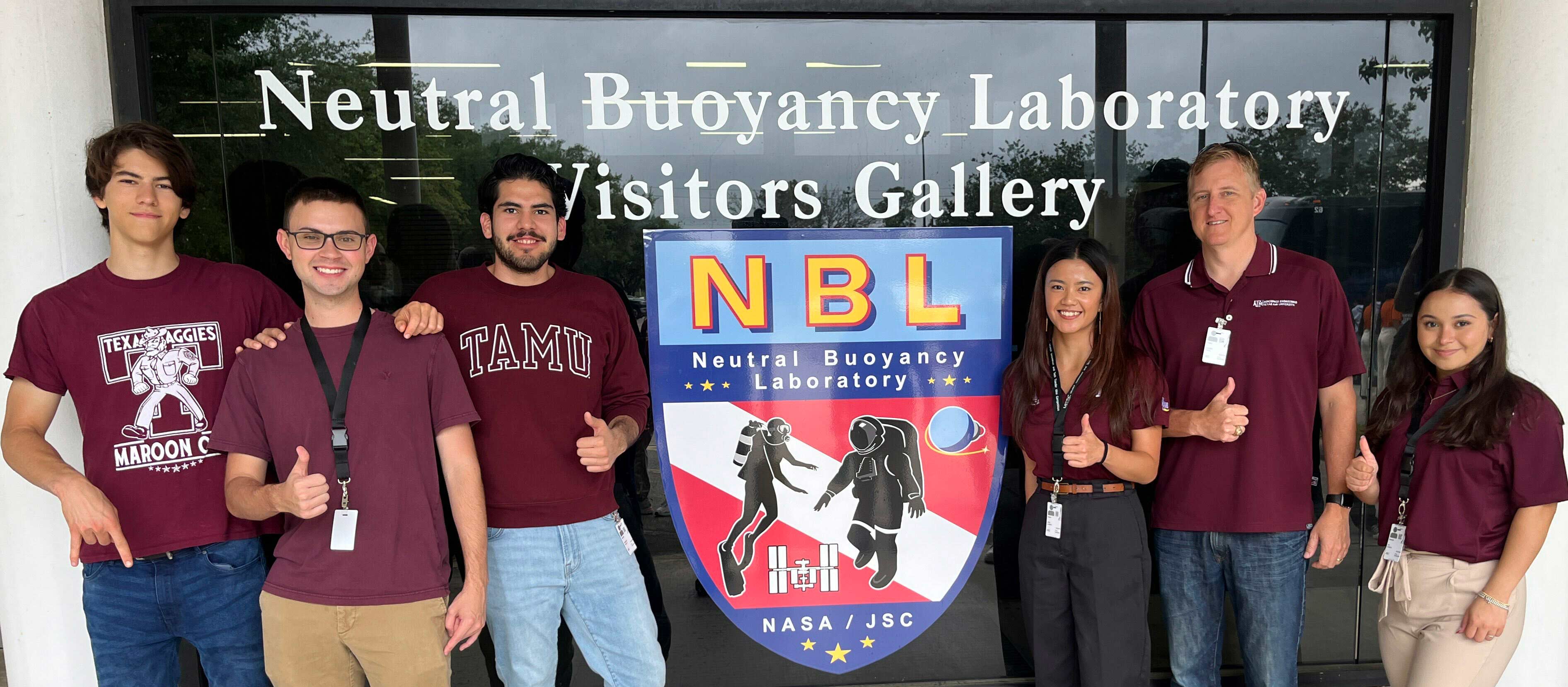 A group of people standing outside of the Neutral Buoyancy Laboratory Visitors Gallery.