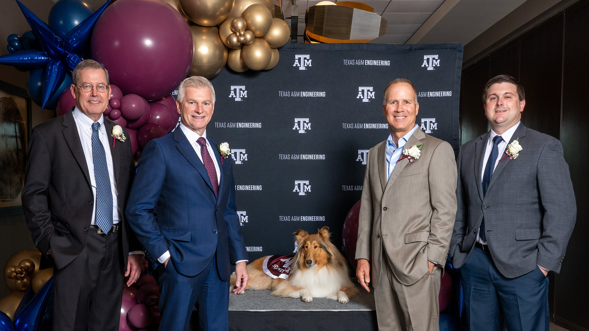 Four men standing with dog.