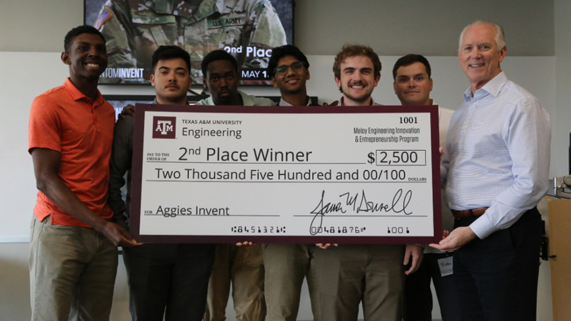 Students holding a large check for $2,500 that says second place winner.