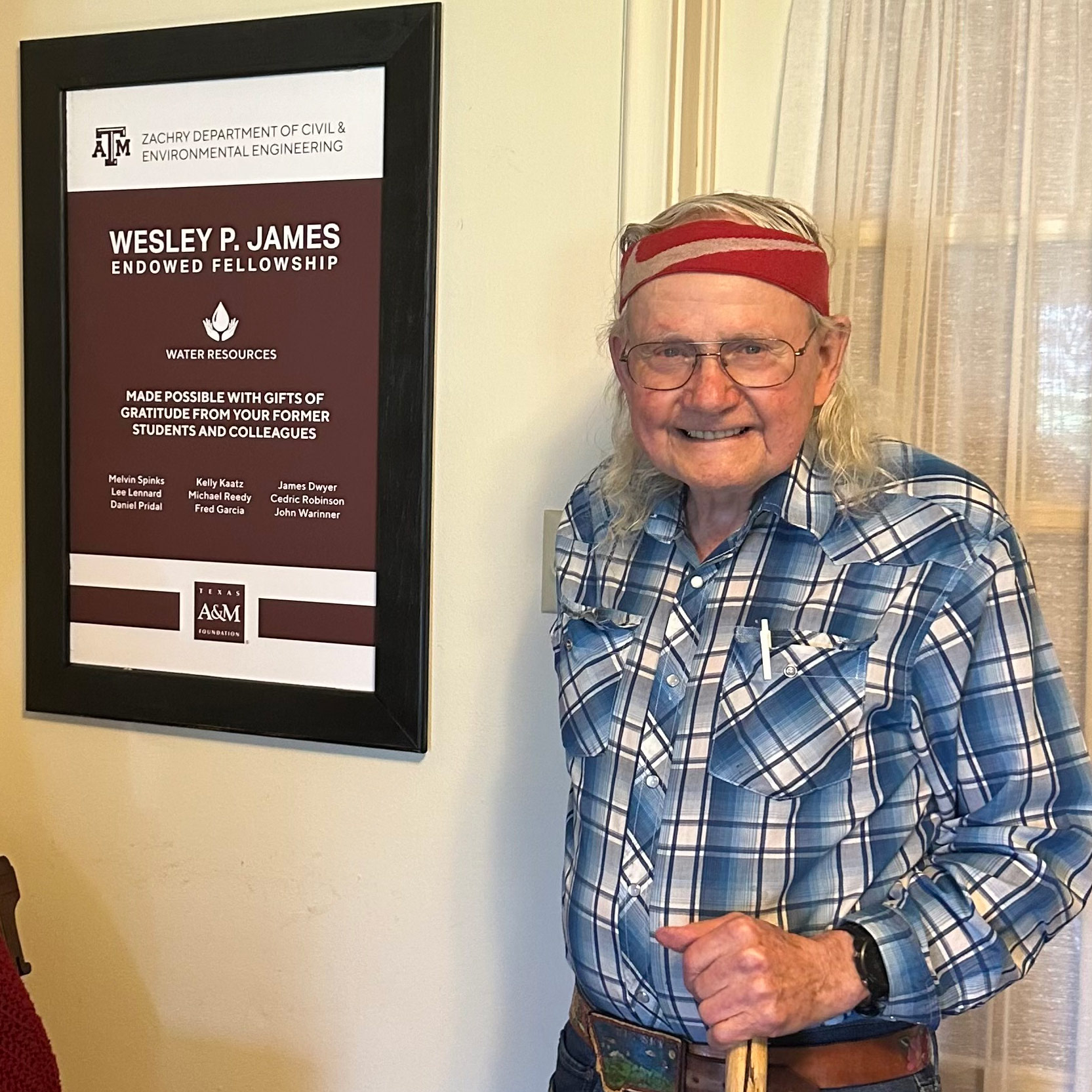  A man poses with a framed poster.