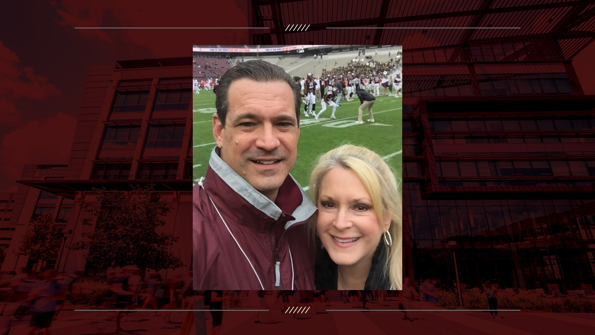 Man and woman smiling in front of a football field.