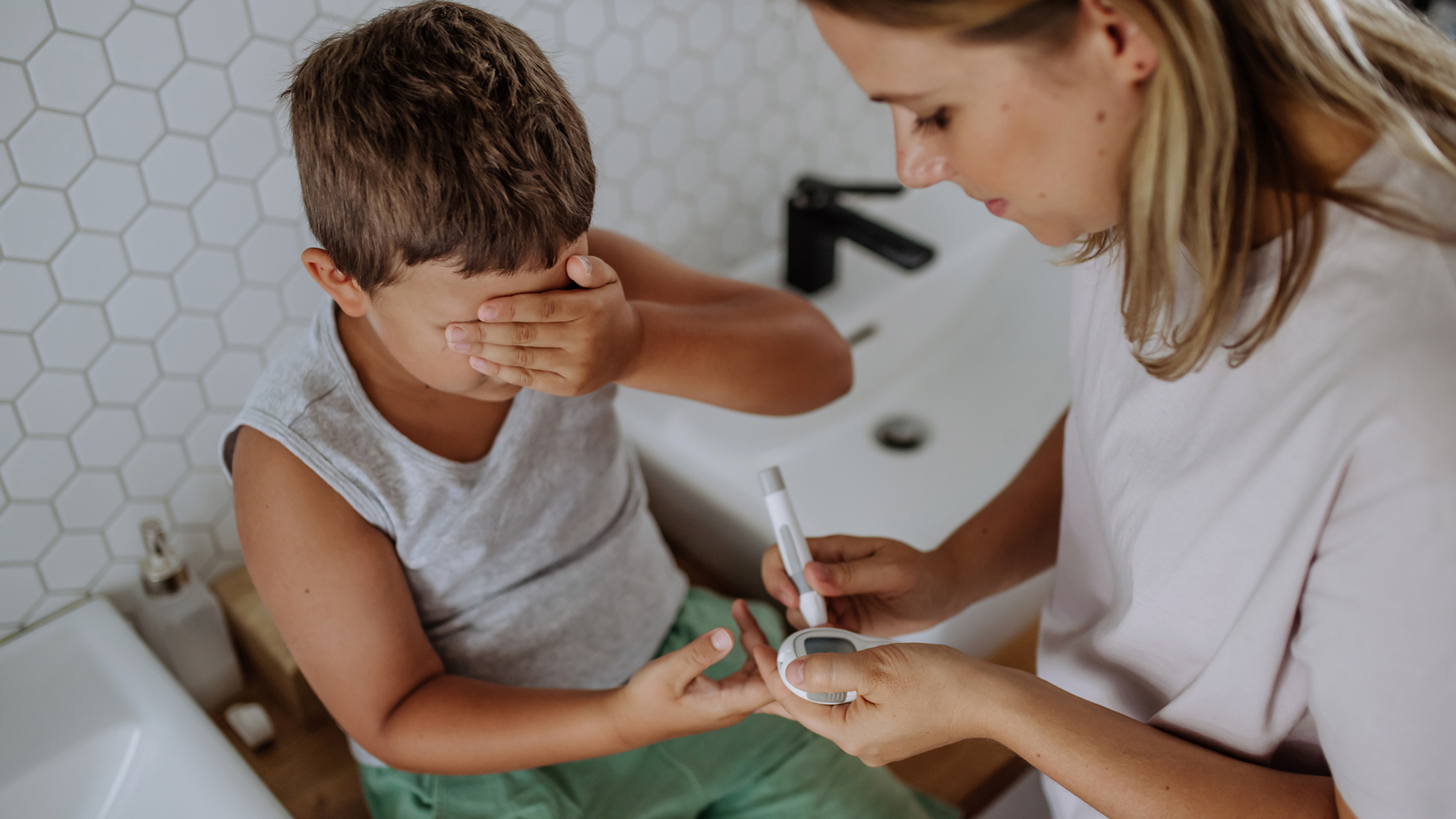 A boy getting tested for diabetes by a doctor.