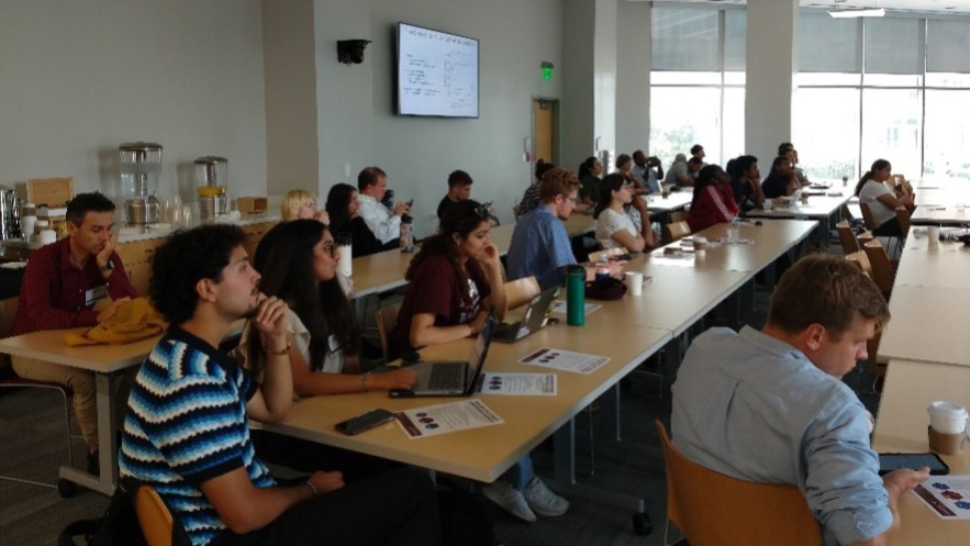 Students in a brightly lit room seated lecture style.