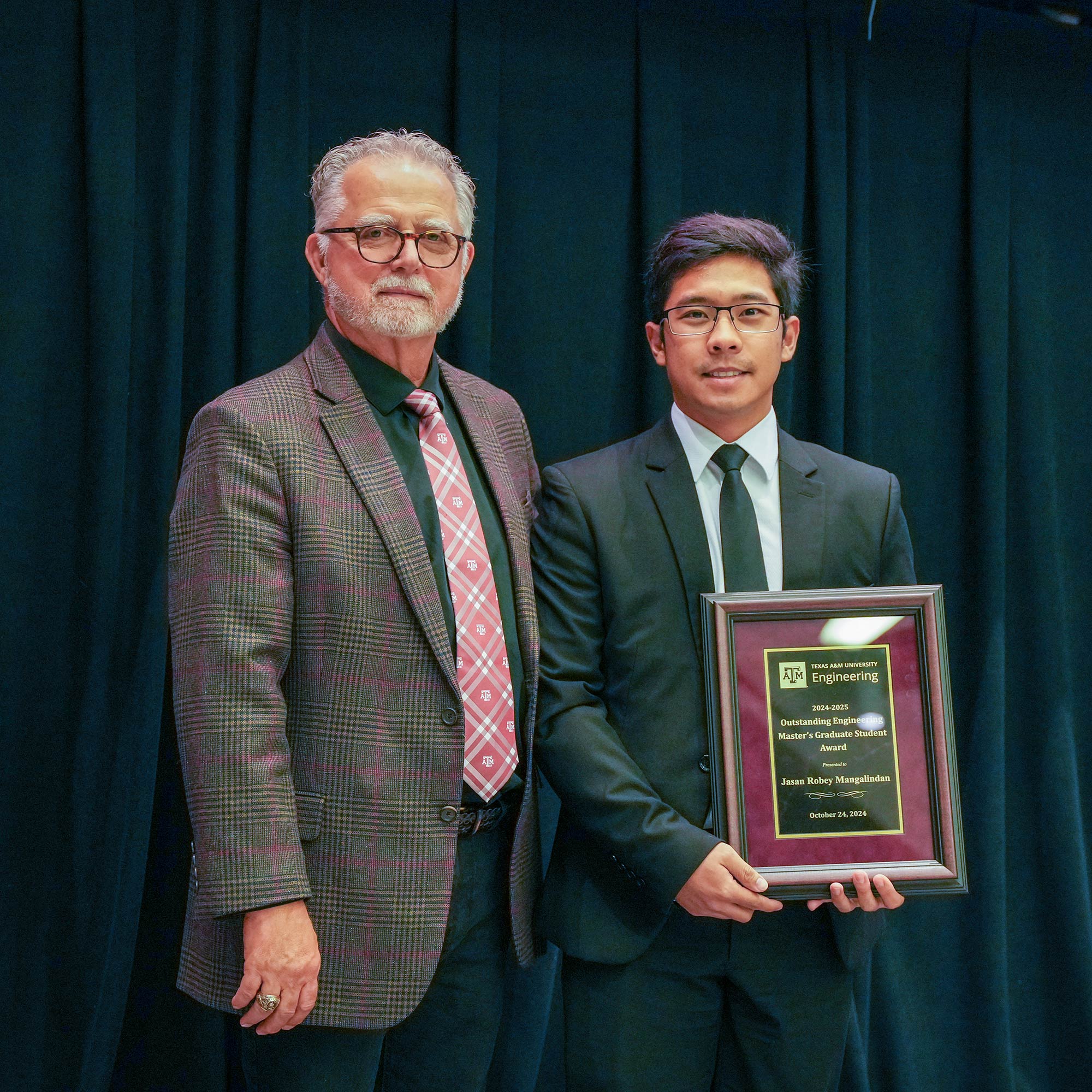 Two men standing, one with a plaque.