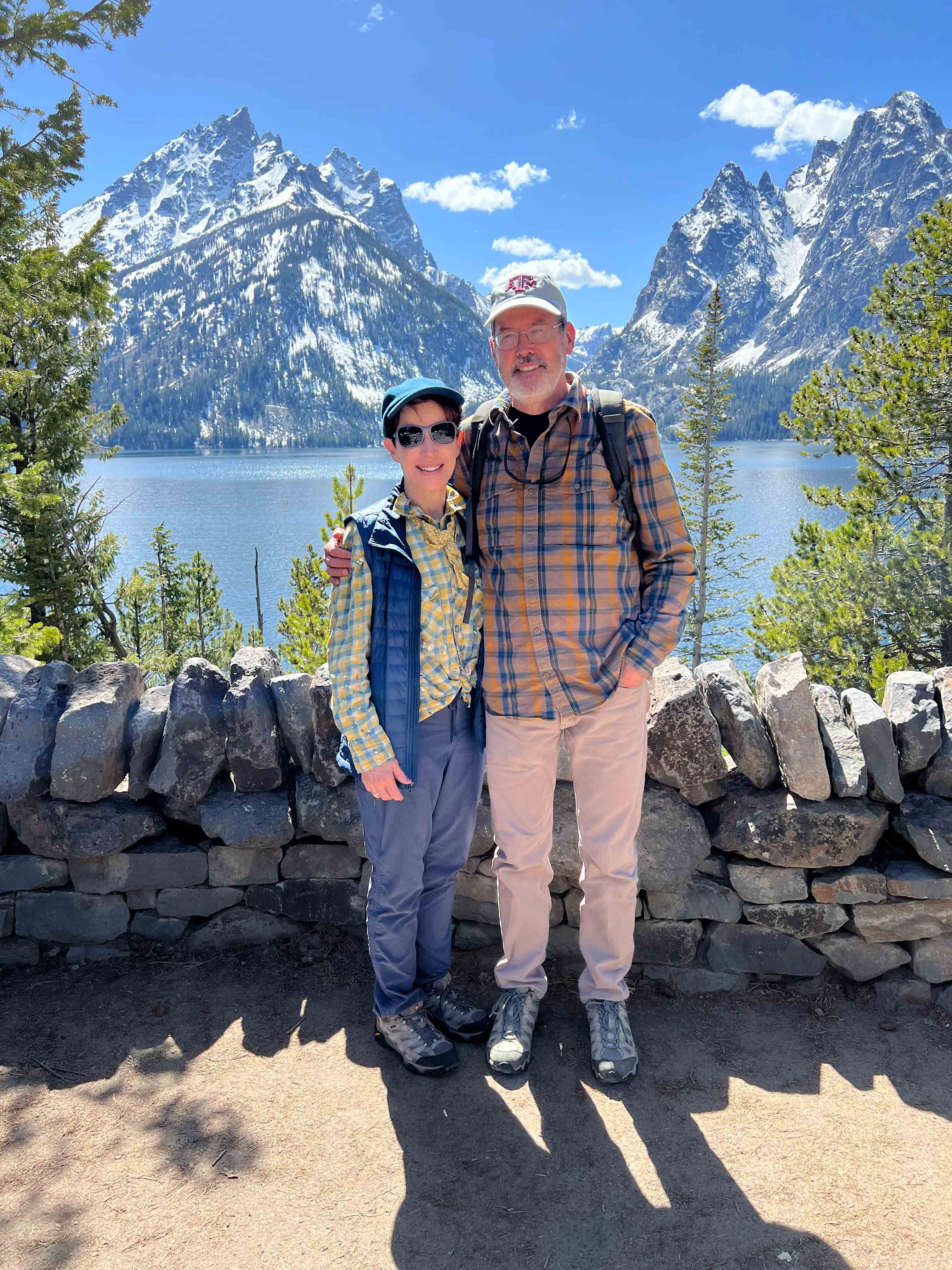 Man and woman standing in front of a mountain scene.