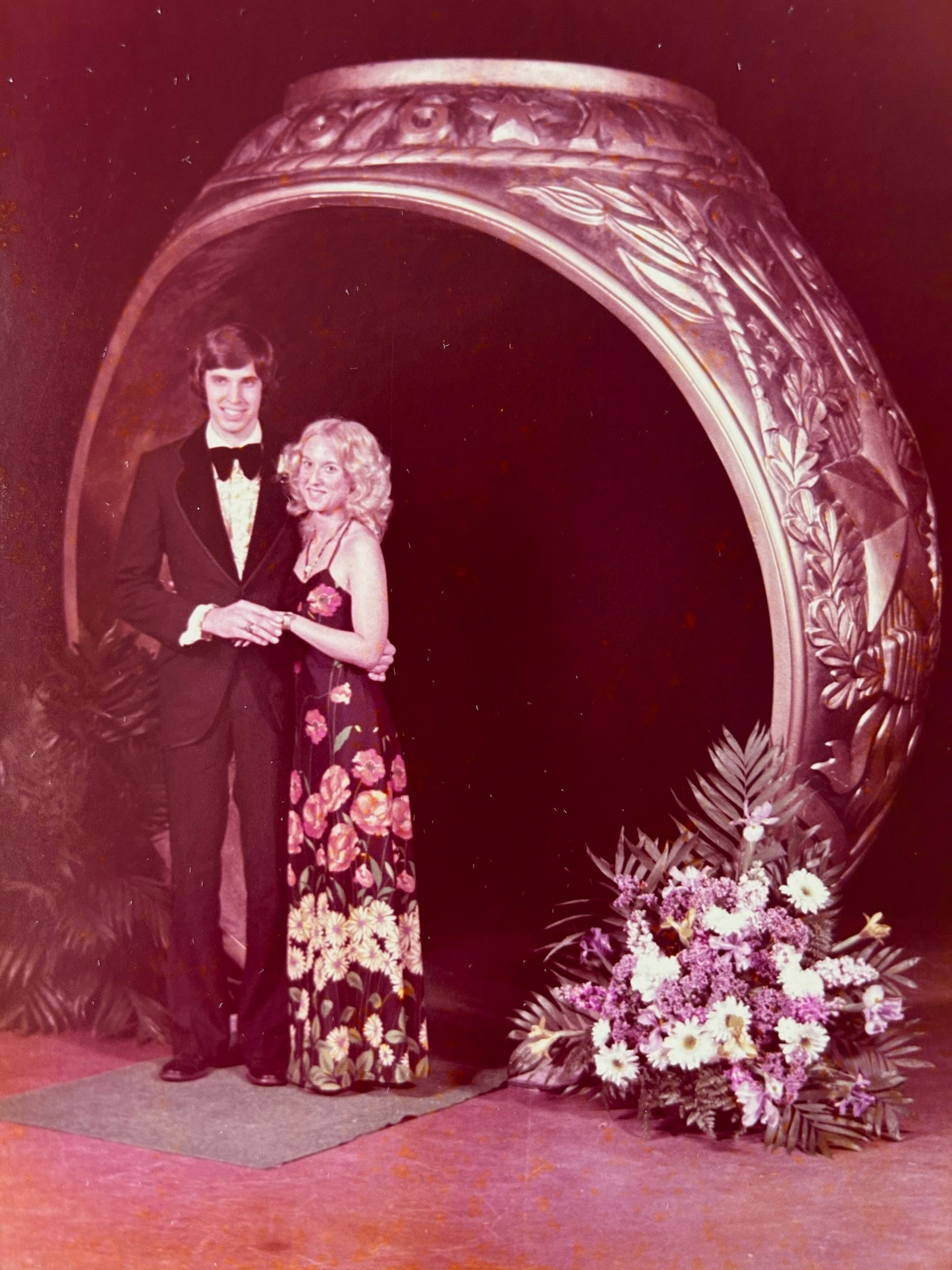  Man and women pose in front of a ring statue.