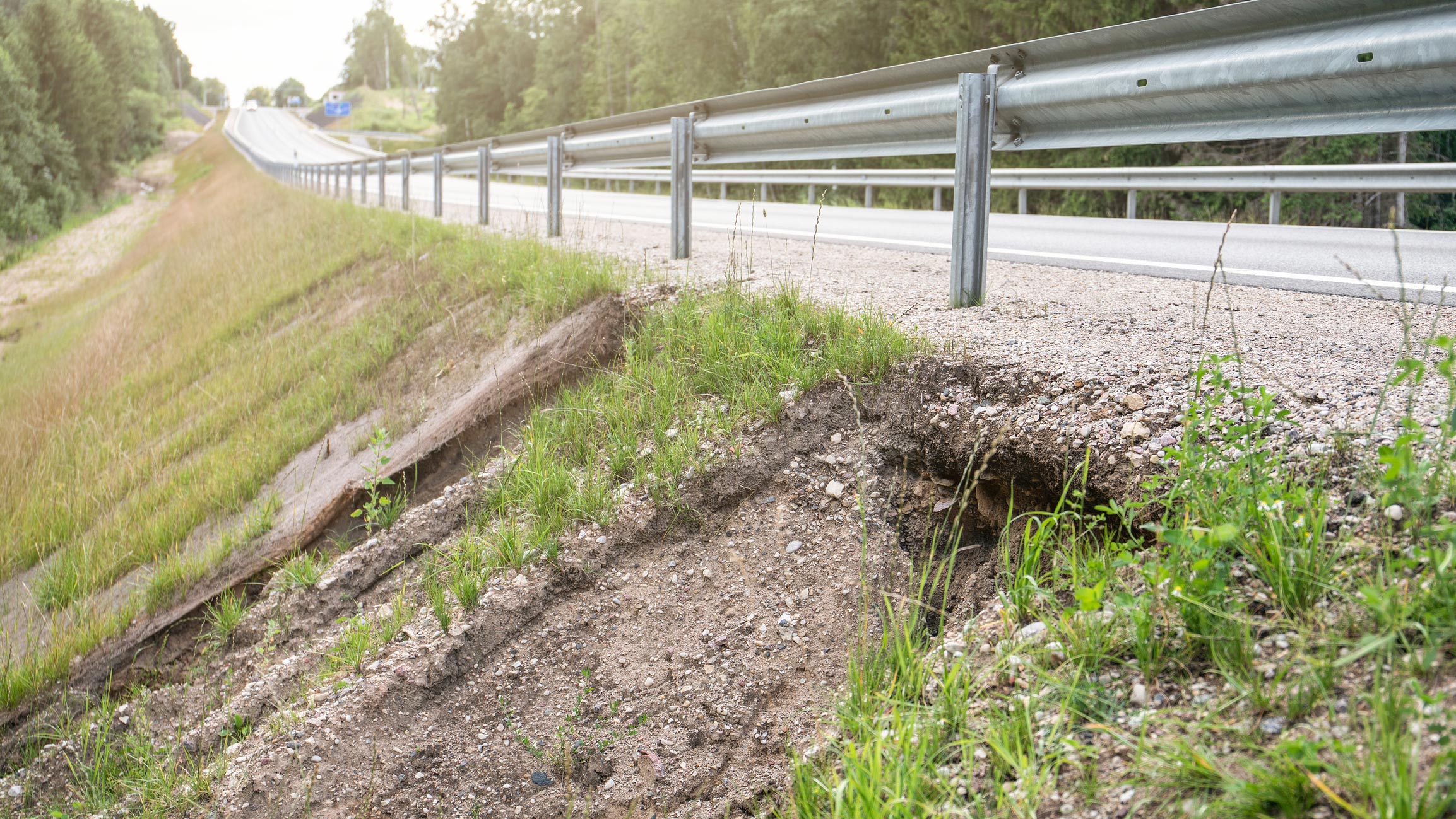 A grassy hillside with a collapsed road.