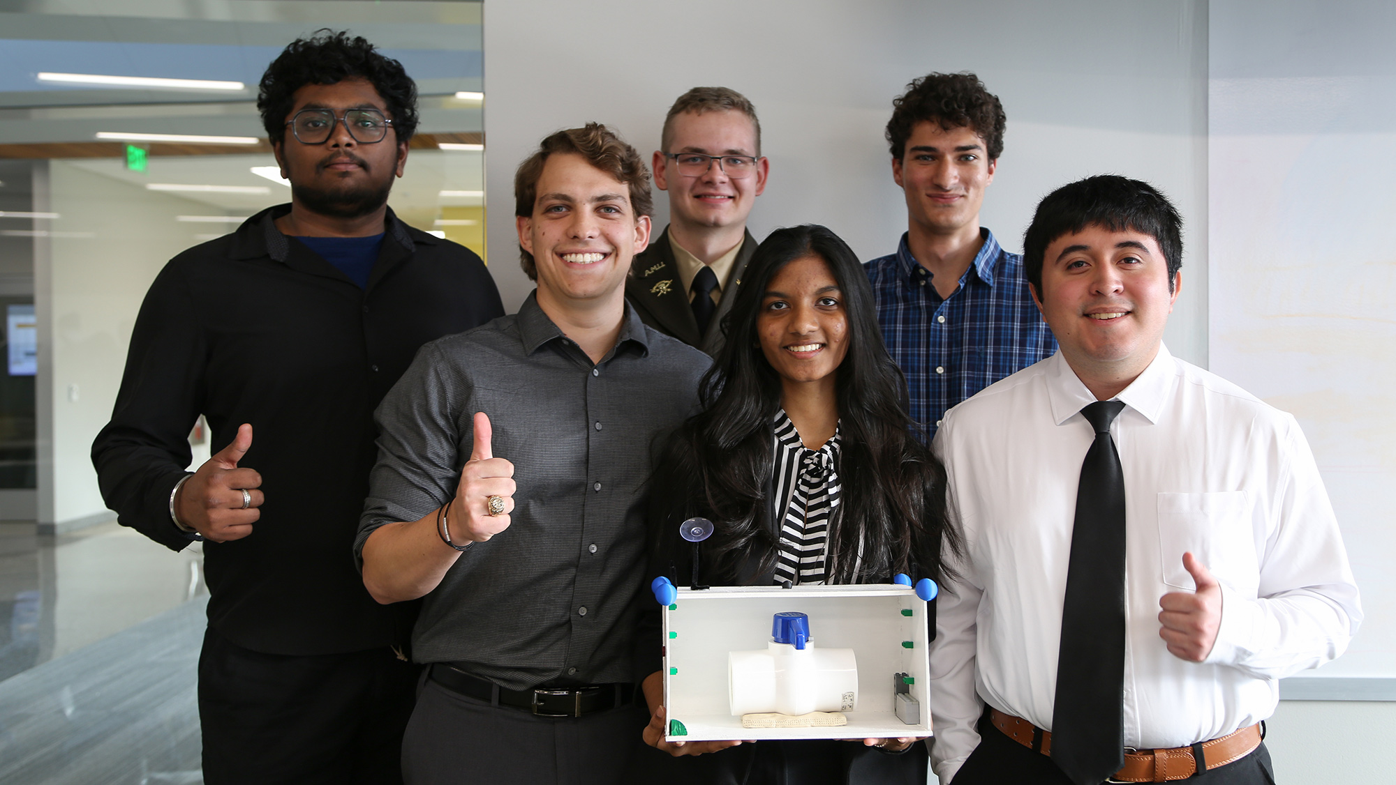 Students stand for a photo with their prototype.