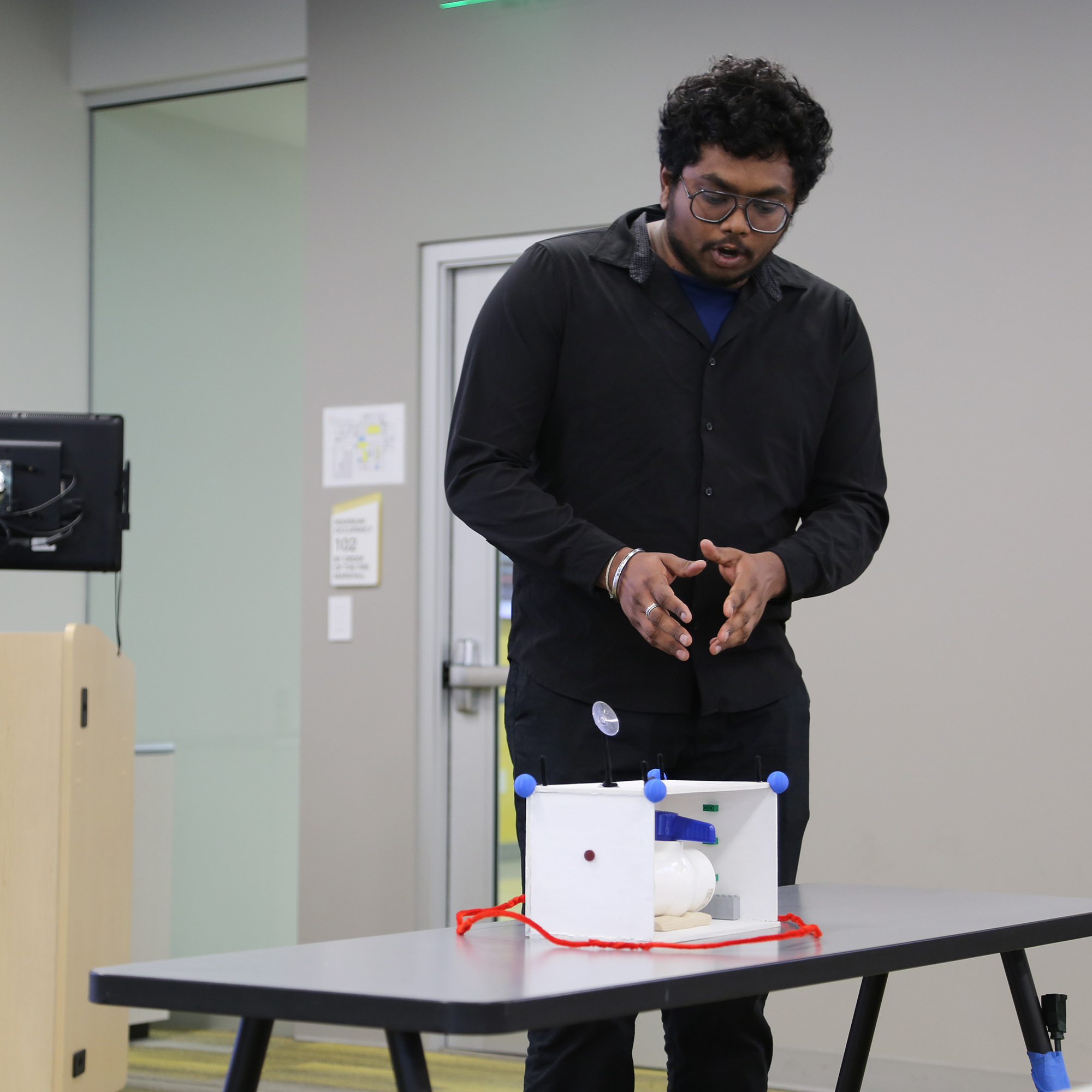 Man presents a prototype to group of judges.