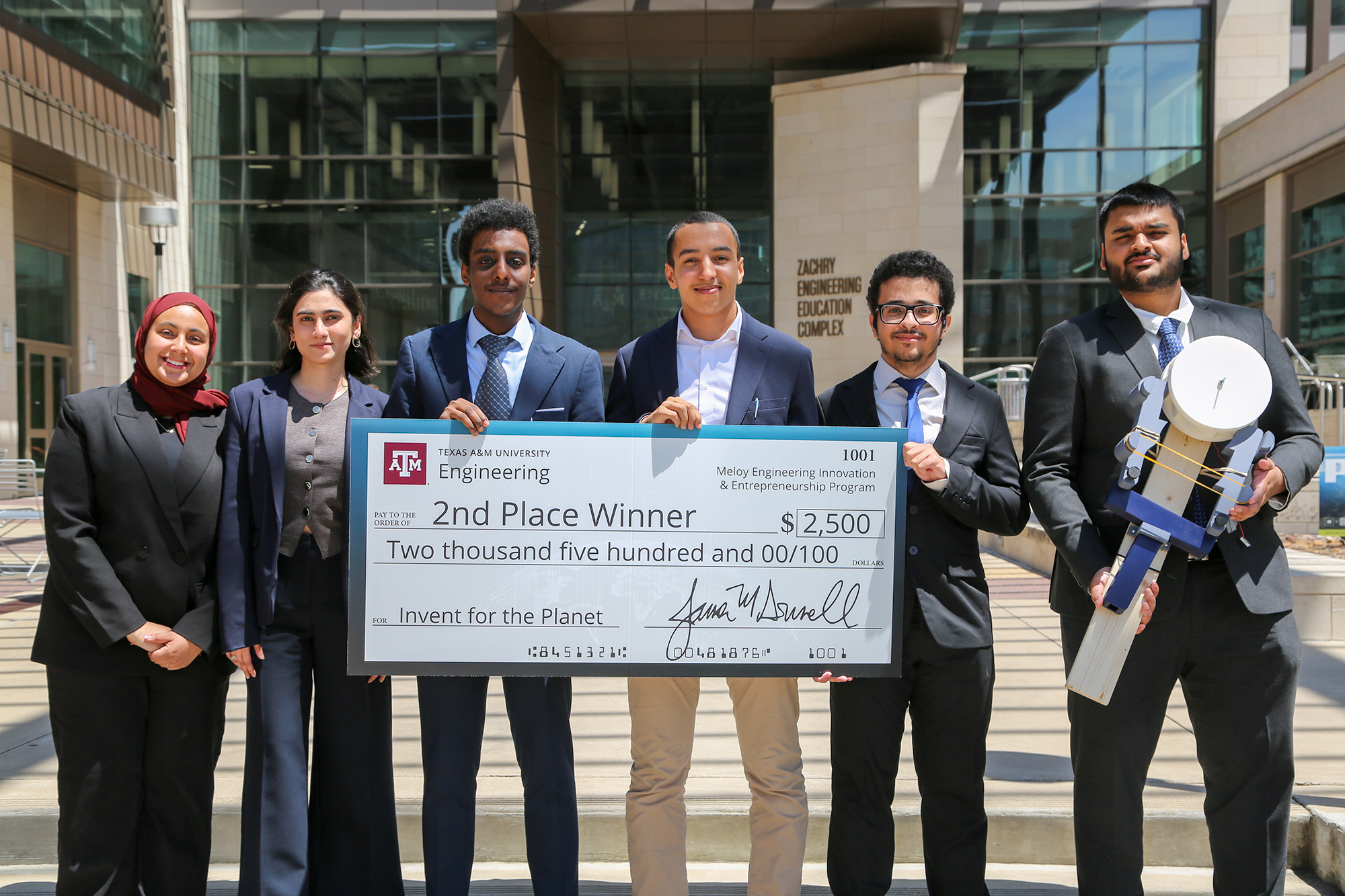 A group of people holding a large check for $2,500.