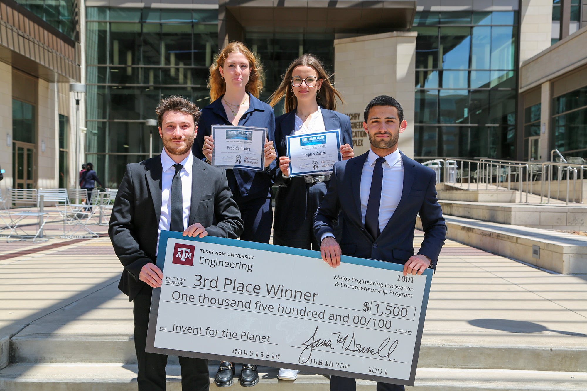A group of people holding a large check for $1,500.