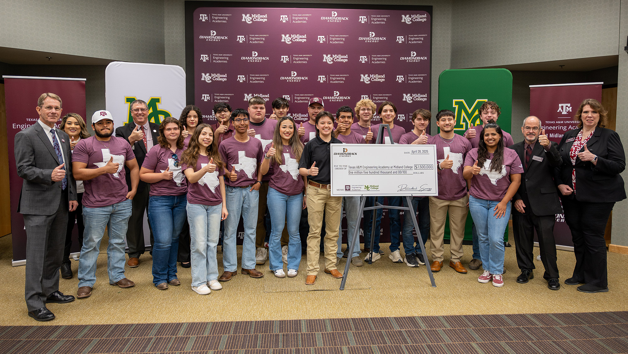 A group of students and academic officials giving a thumbs-up post alongside a ceremonial check. 