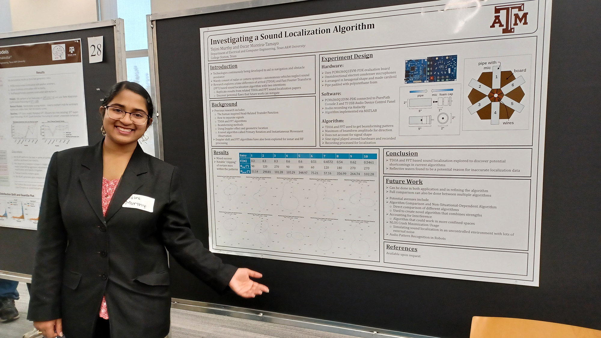 A young woman with dark hair and glasses stands next to her research poster.