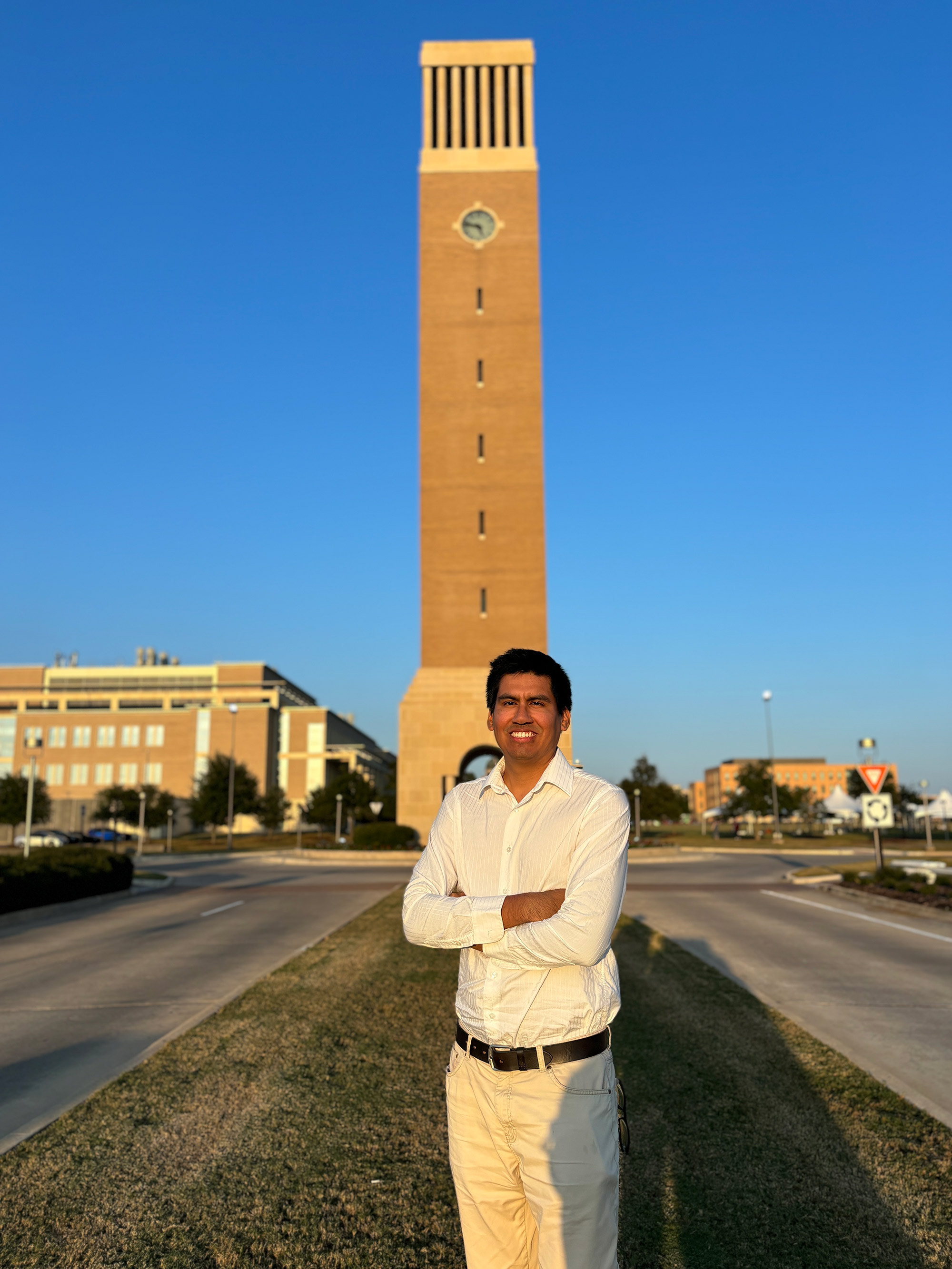 A man standing outside a bell tower.