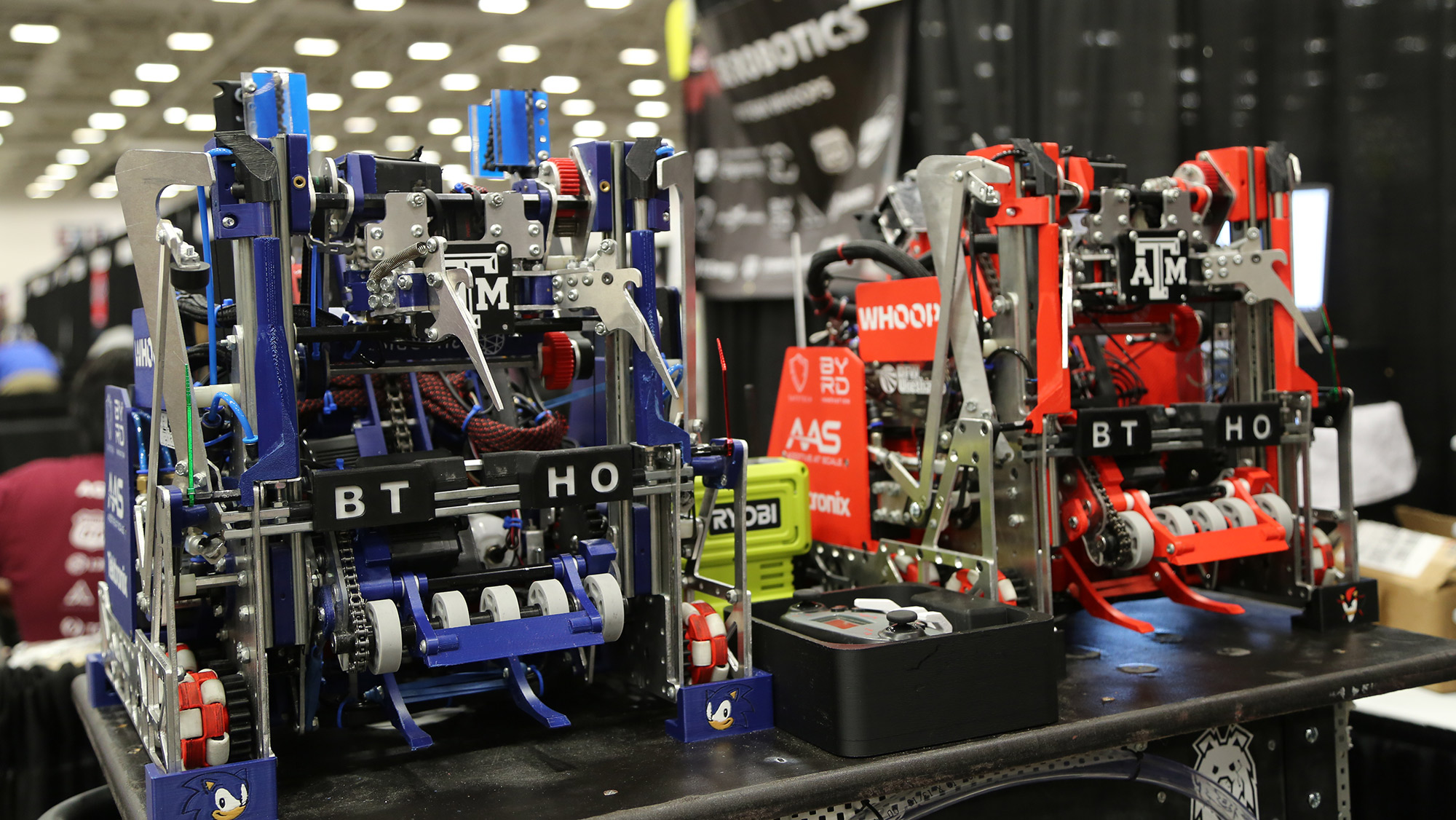 A blue and a red robot on a table. 