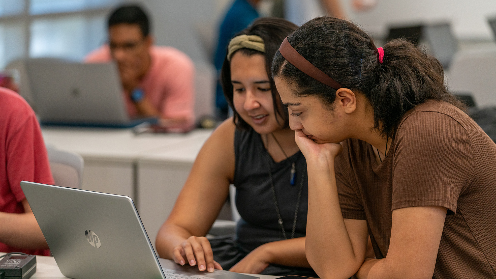 Two students working on a laptop.