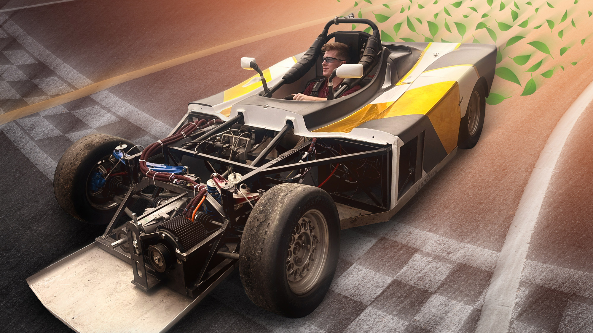 A student sitting in a prototype race car on an animated race track background. 
