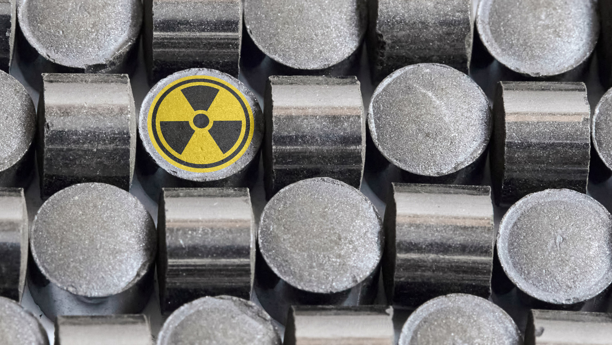 The nuclear power logo on top of metal fuel pellets.