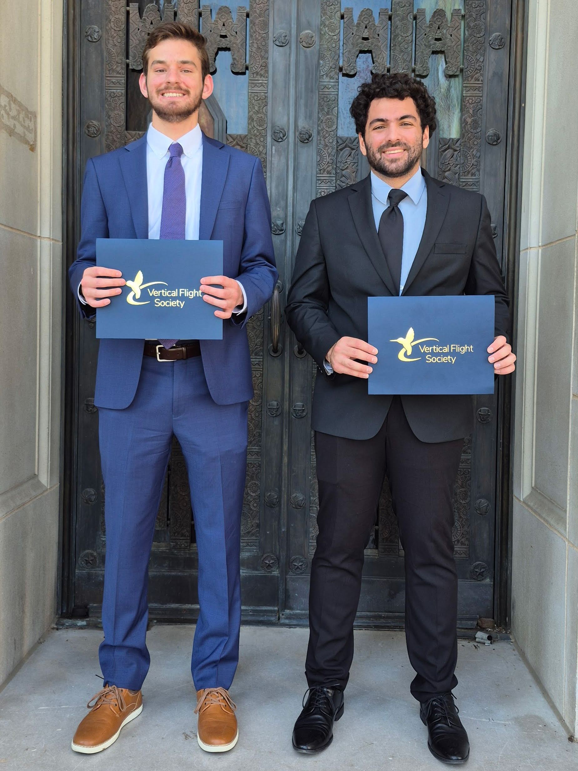 Two men holding certificates.