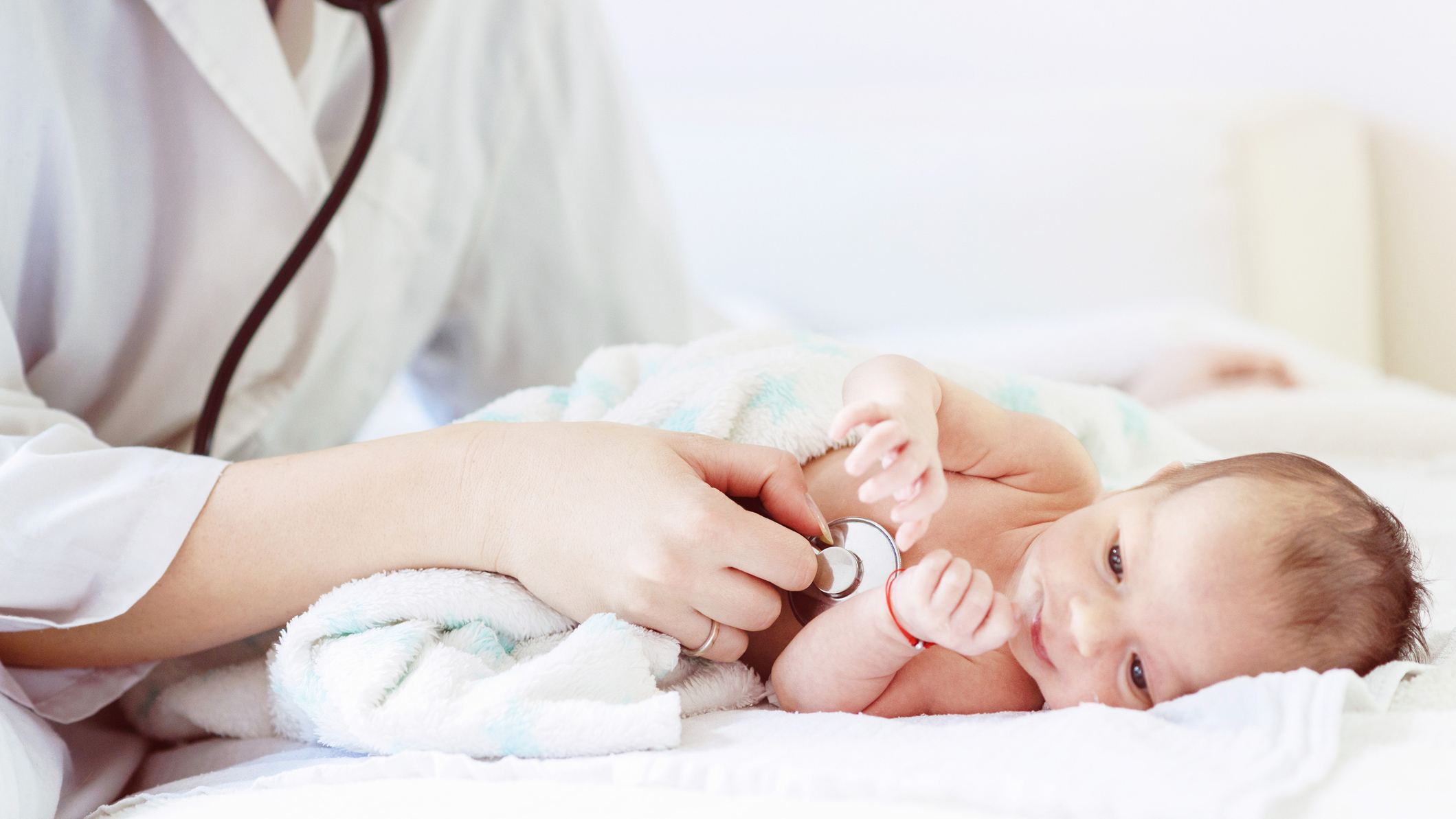 An doctor using a stethoscope on a baby.
