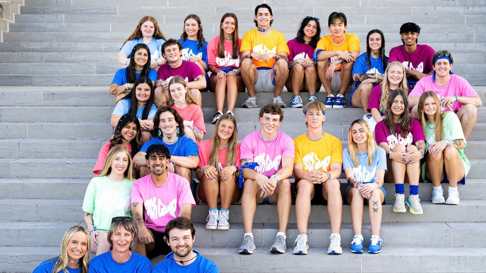 A group of people sitting in the shape of a P.