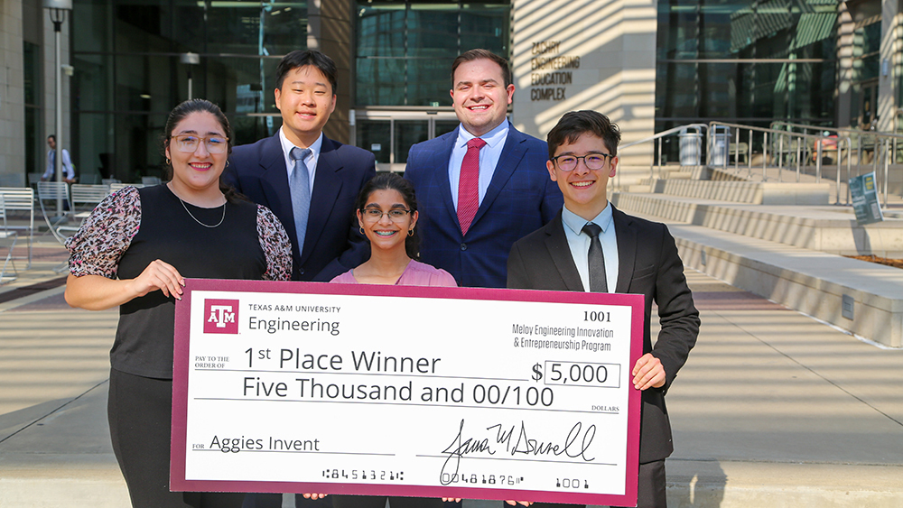 A group of students holding an oversized check.
