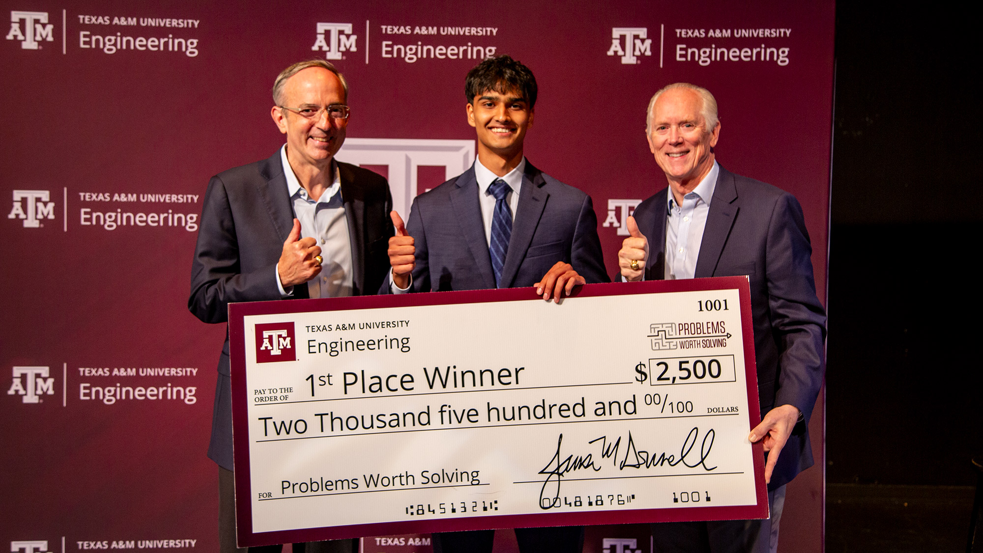 Three people smiling with an oversized check.