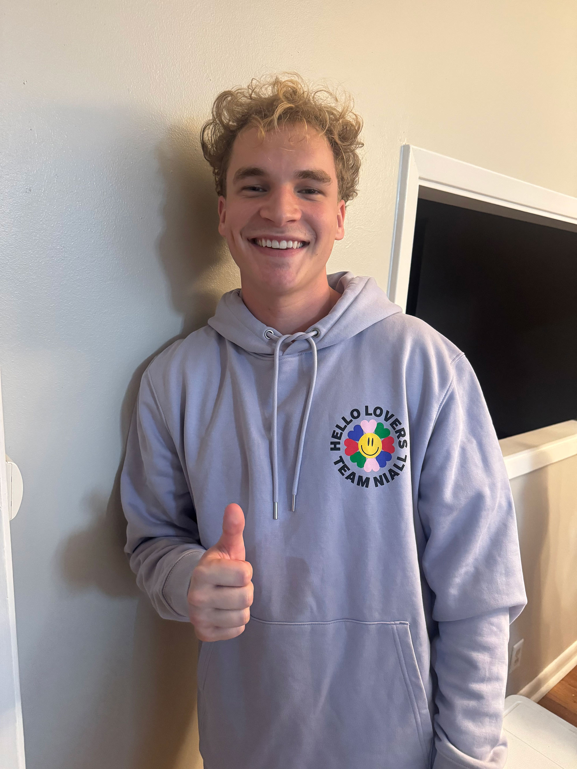 Aiden Ross wearing a Team Niall hoodie, making a Gig 'Em with his hand.