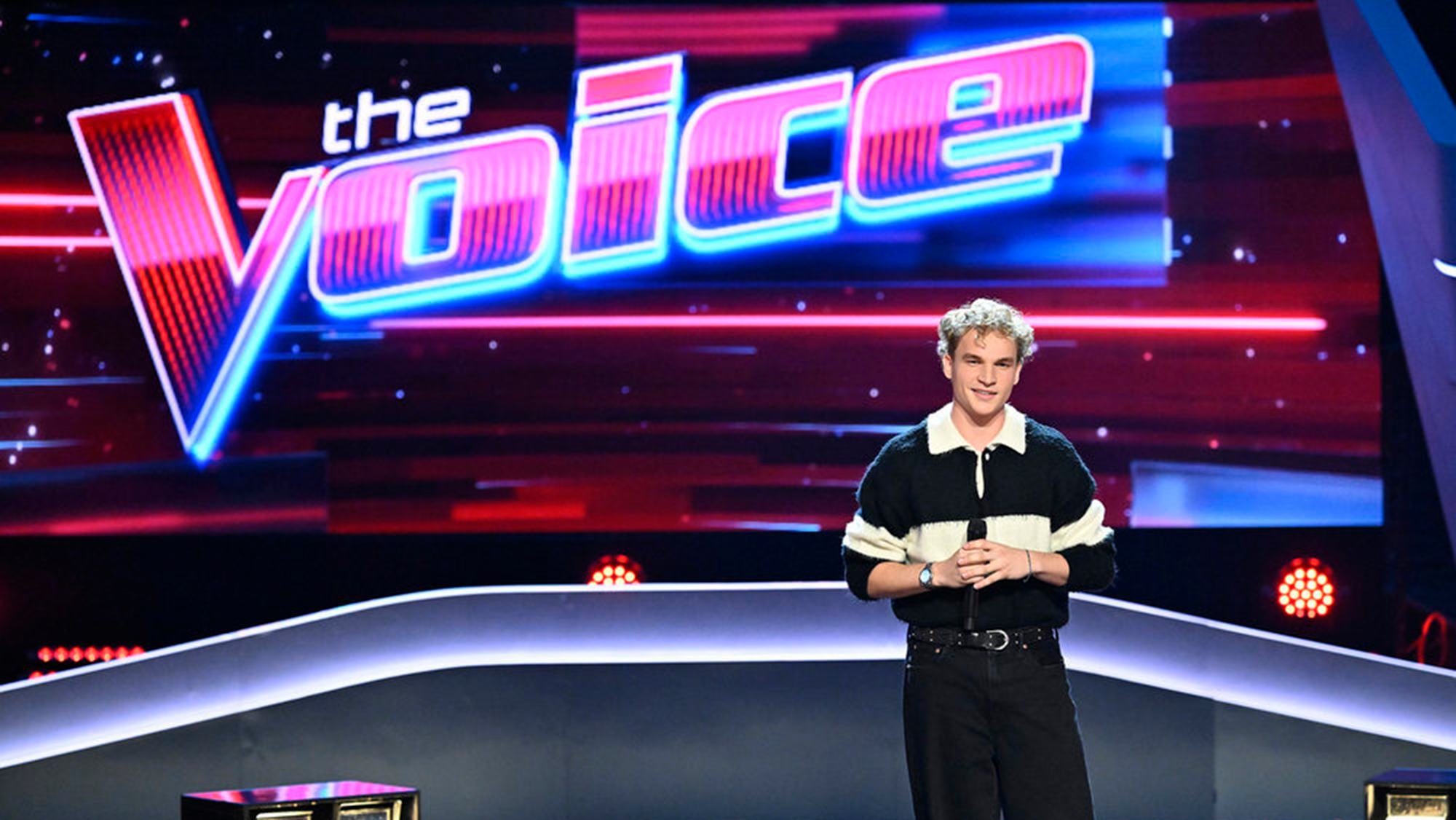 Aiden Ross standing on The Voice stage. 