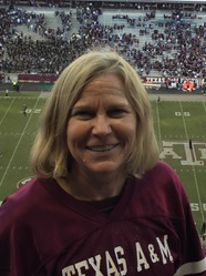 A woman smiling at a football game.