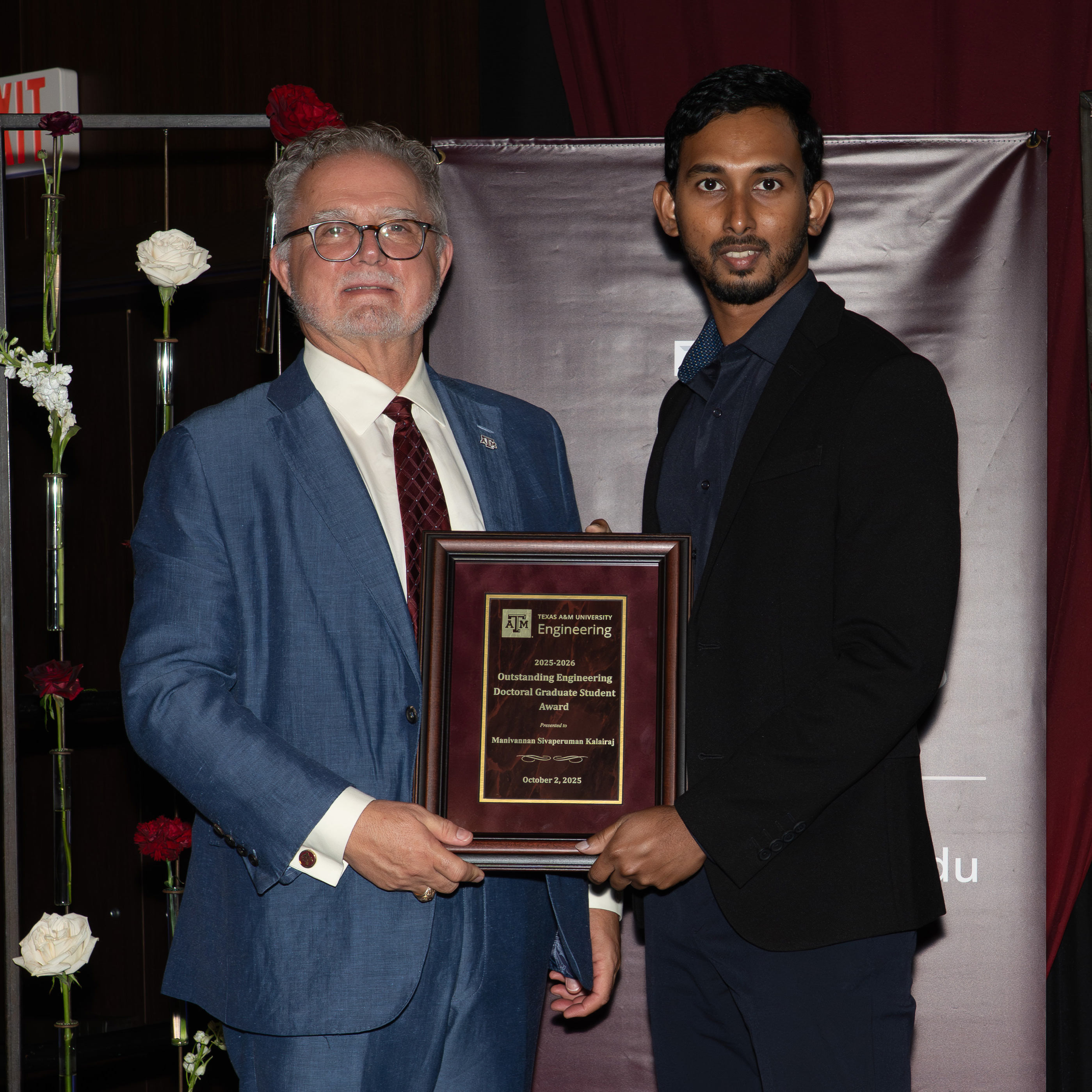 Two men pose with an awards.