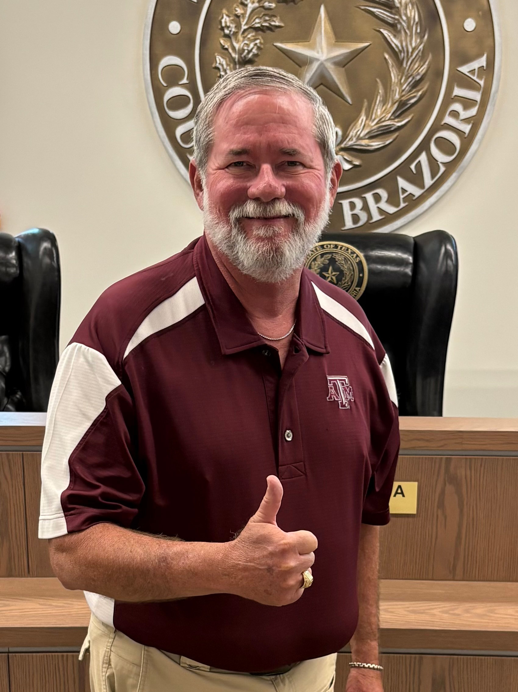 Judge Leonard Matthew Sebesta Jr. stands indoors at the courthouse in front of a large State of Texas Brazoria County seal.