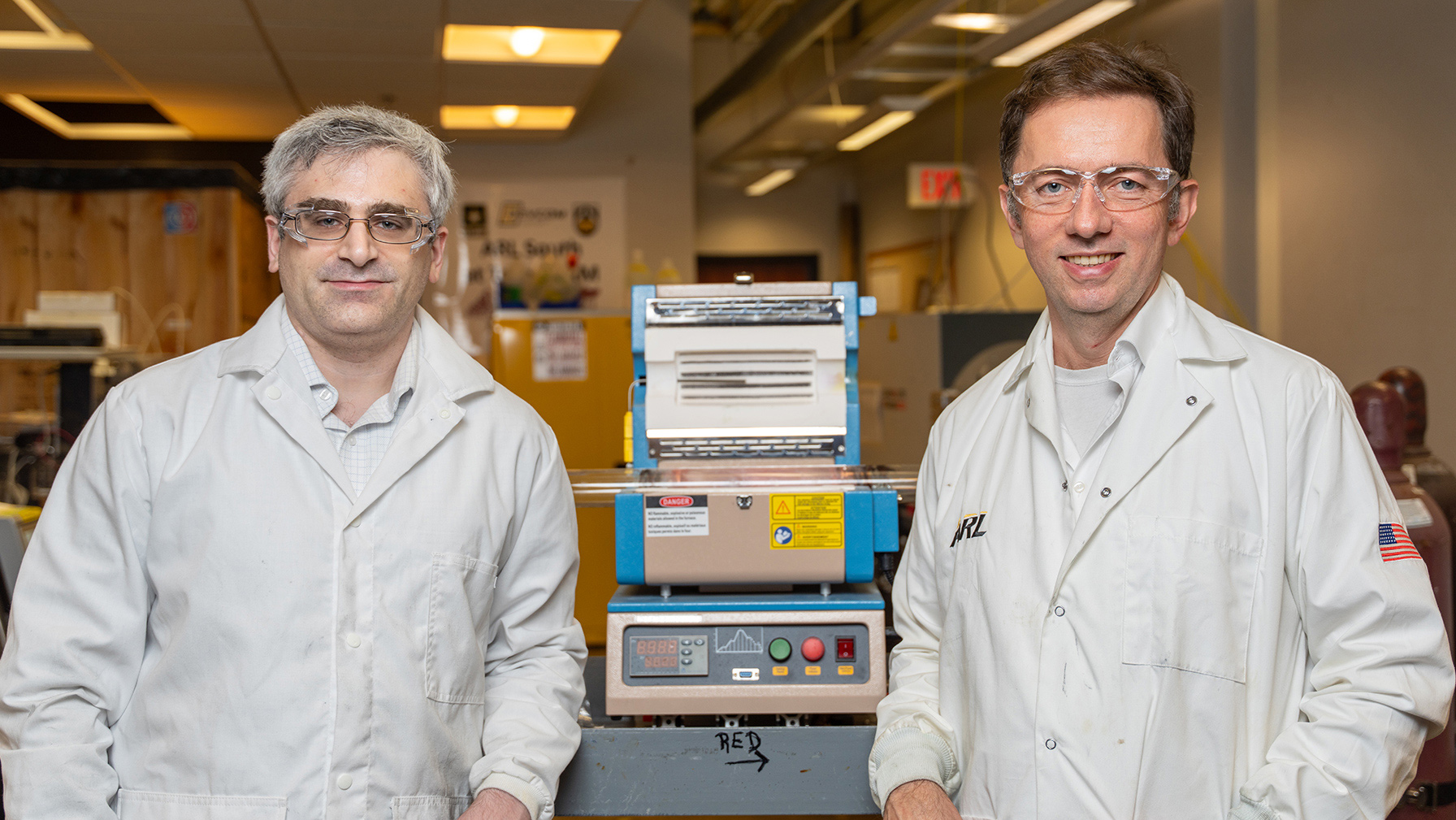 Two men standing with lab equipment.