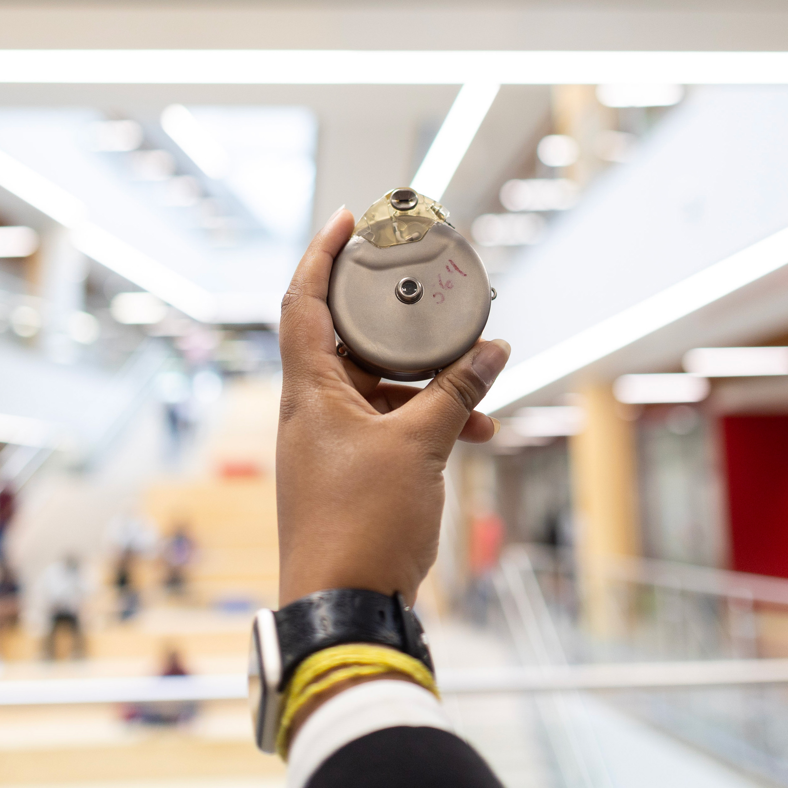 A hand holding a circular medal device. 