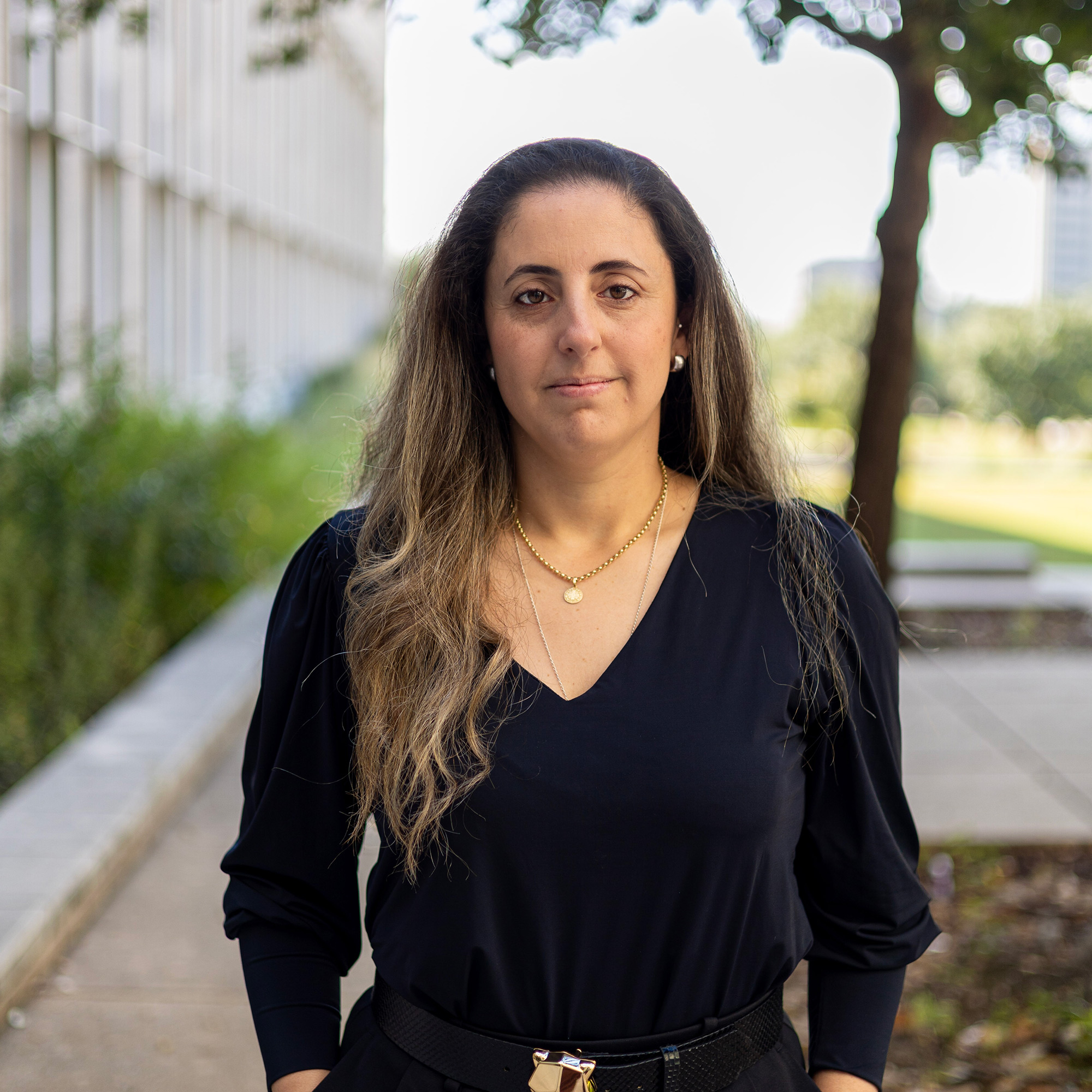 A person in professional attire, smiling.