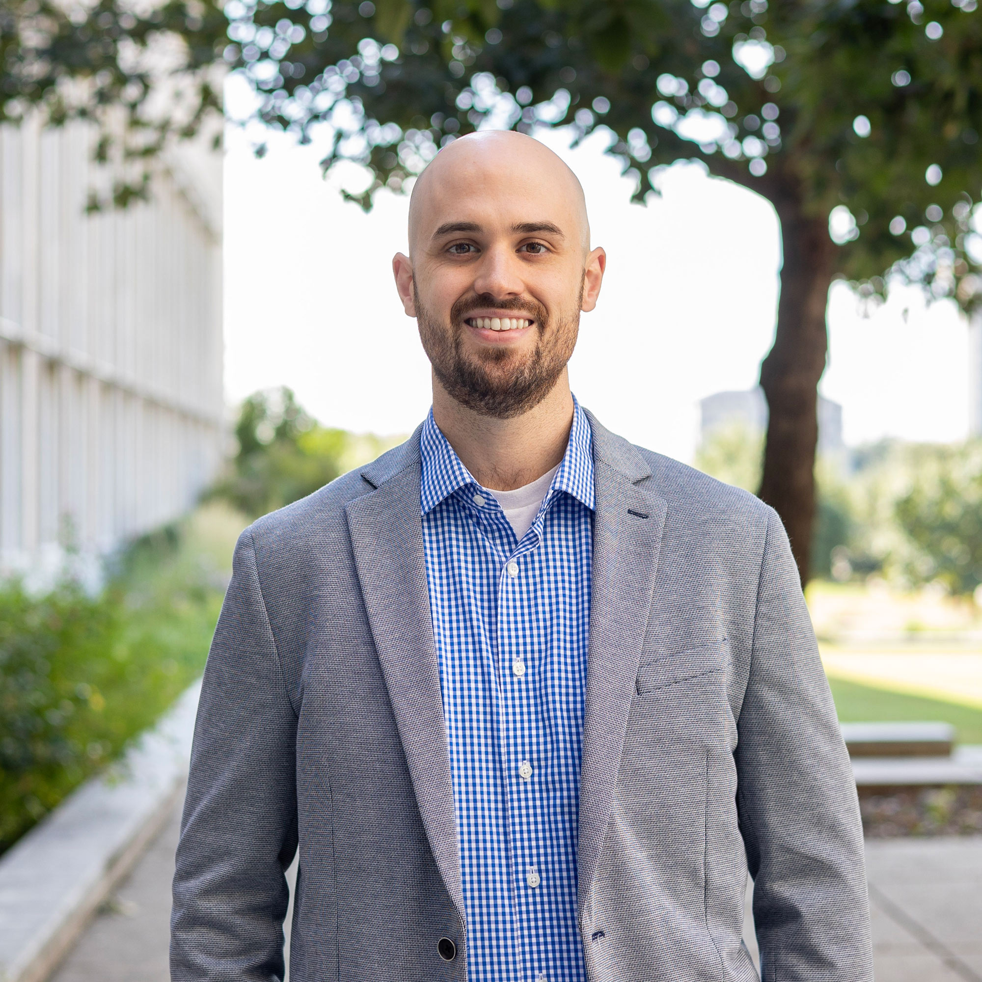 A person in a suit, smiling.